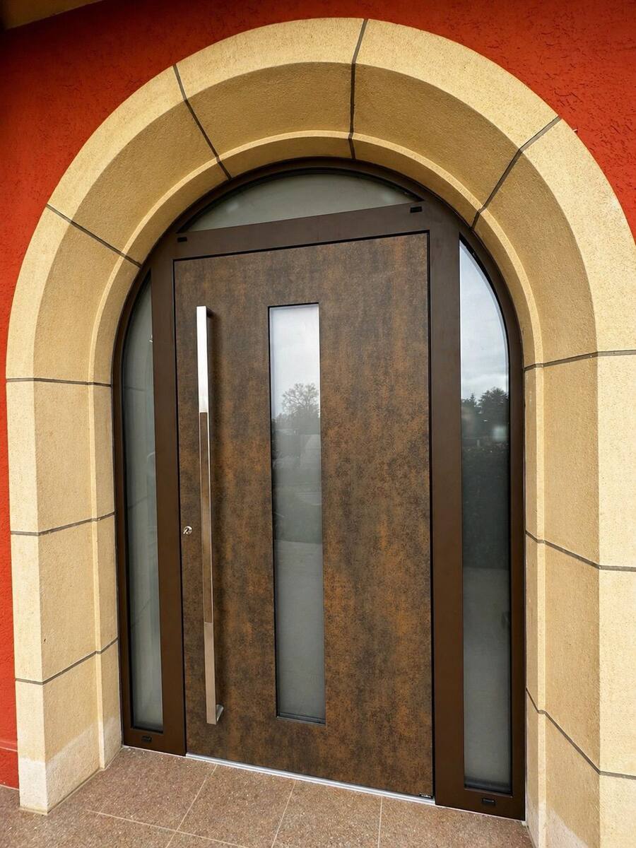 Porte d'entrée bois sous une arche en pierre