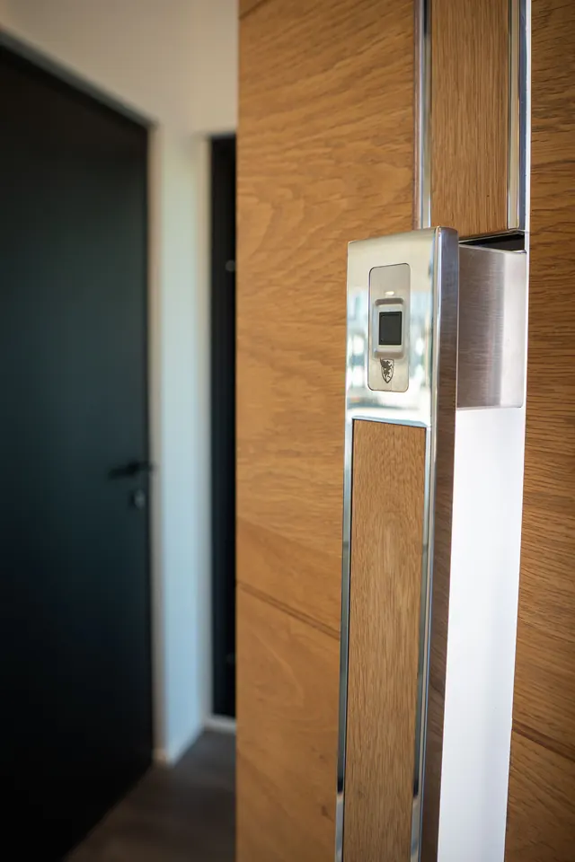 Porte d'entrée sombre avec habillage bois dans le showroom
